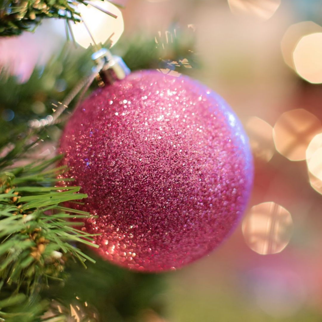 Pink sparkly ball tree decoration on Christmas tree.