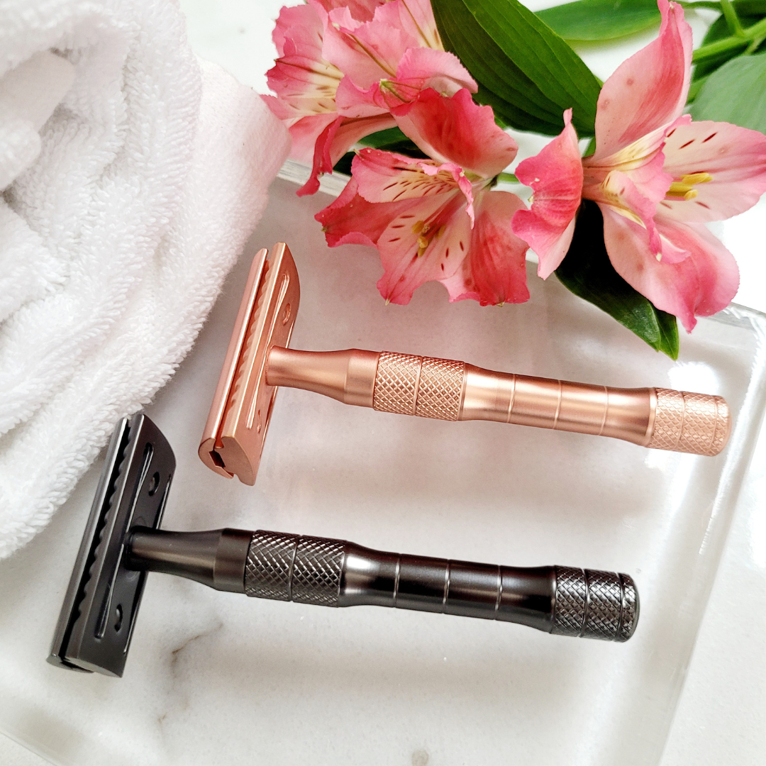 A close-up of matte black and rose gold double-edge safety razors, designed for smooth, plastic-free shaving with a premium zinc alloy head and brass handle.