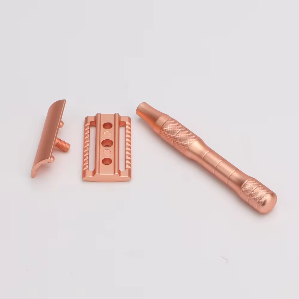 A disassembled rose gold safety razor showcasing its three-part construction for easy blade replacement and a perfectly balanced shave.
