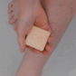 A Caley-Beth Shave Balm Bar held in hand, ready to provide a hydrating, irritation-free shave with its nourishing formula. Made in Canada and plastic-free.