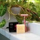  A Caley-Beth Shave Balm Bar next to a razor, designed to provide a silky-smooth shave without irritation or razor burn. Canadian-made.