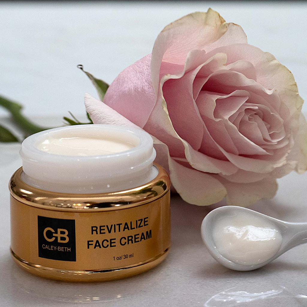 Caley-Beth Revitalize Face Cream with a pink rose, and a mini spoon of cream.